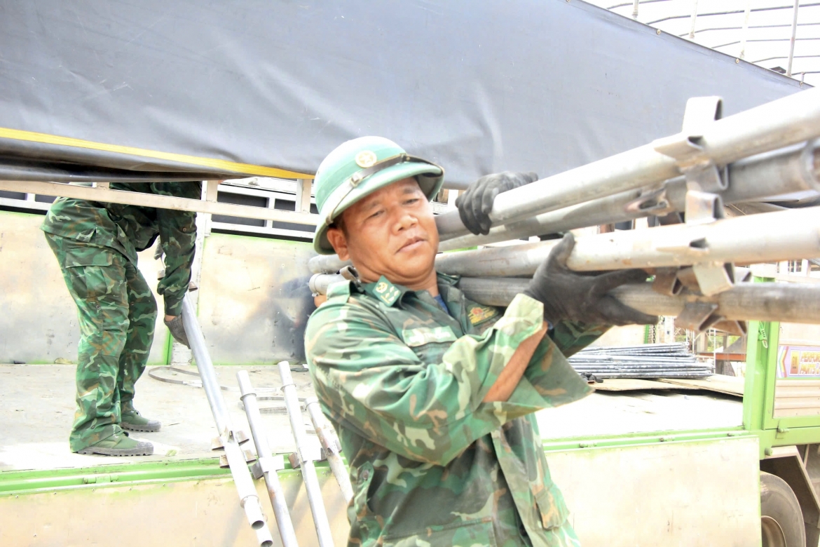 Bộ đội biên phòng vận chuyển giàn giáo vào công trình.