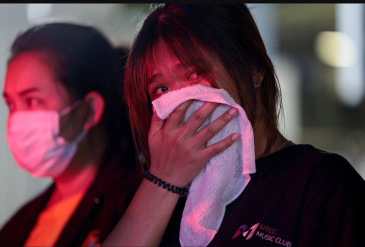 Một cô gái có chị thiệt mạng trong vụ hỏa hoạn tại quán bar ở Bangkok phản ứng gần hiện trường ngày 13/7 - Ảnh: REUTERS