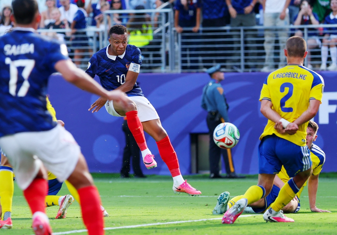Mbappe tung cú sút thành bàn giữa vòng vây hậu vệ Thụy Điển. (Ảnh: Reuters)