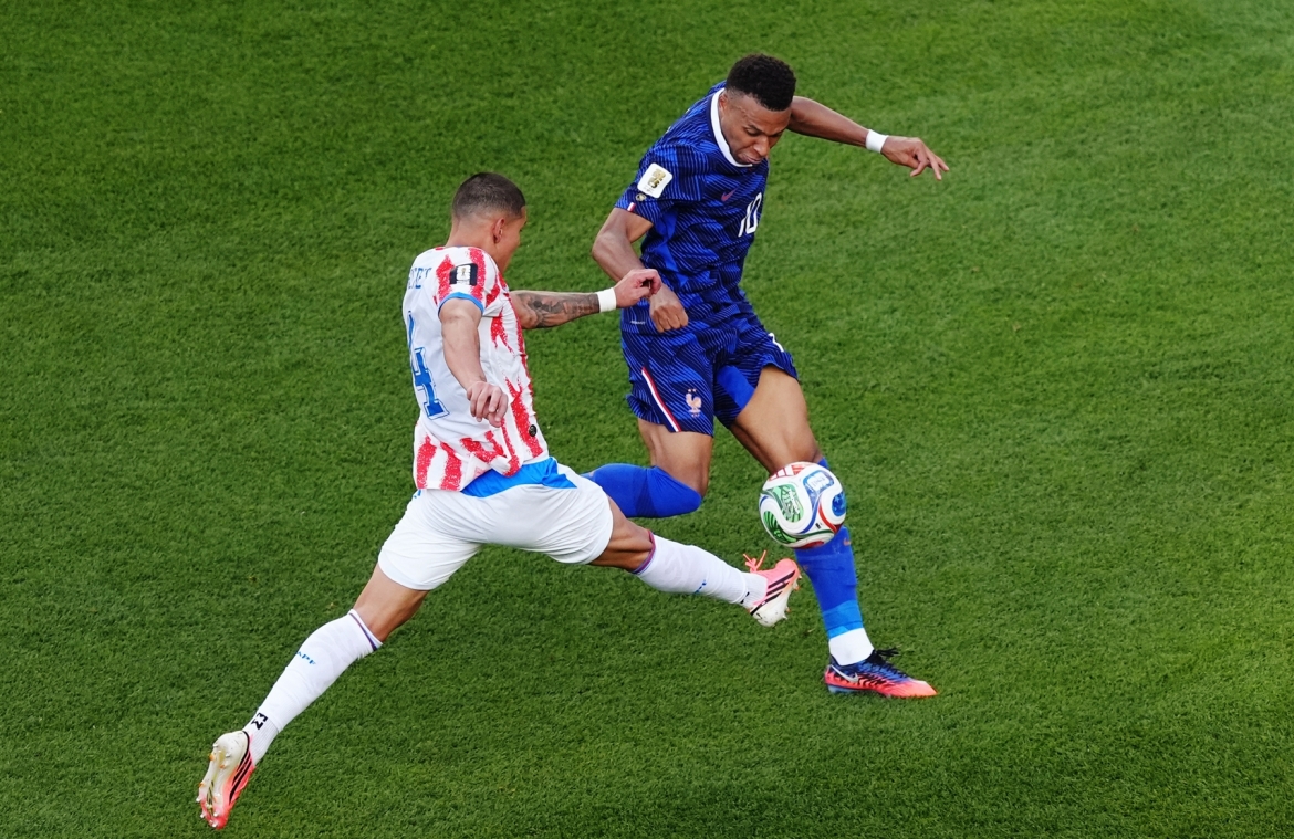 Hậu vệ Paraguay phá bóng chịu phạt góc khi Mbappe xử lý lỗi. (Ảnh: Reuters)