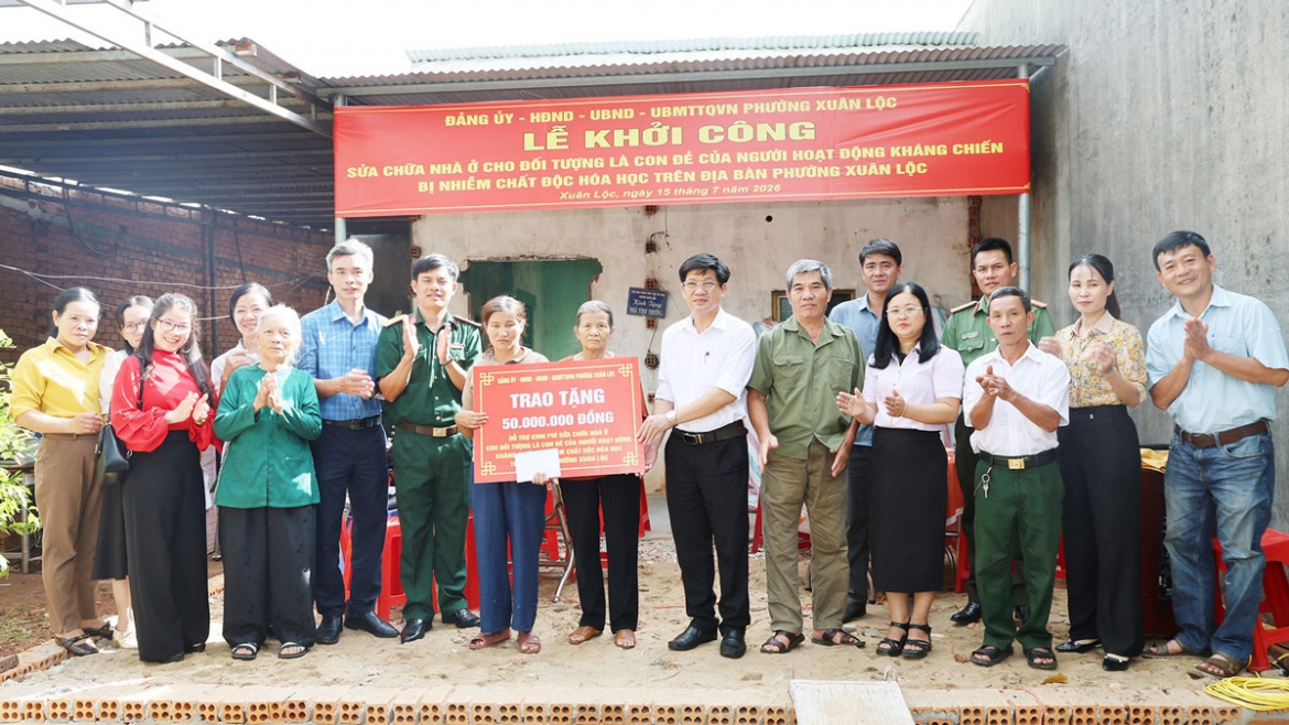 Lãnh đạo phường Xuân Lộc và các đoàn thể trao bảng tượng trưng 50 triệu đồng hỗ trợ sửa chữa nhà cho gia đình bà Nguyễn Thị Loan (Ảnh: Ngọc Hoàng)