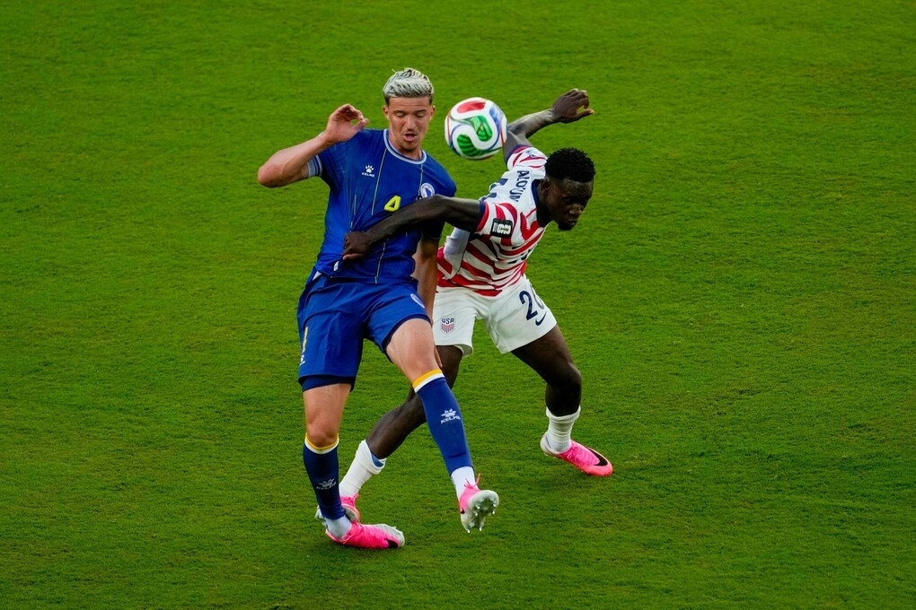 Tiền đạo Mỹ Folarin Balogun (20) phạm lỗi với Tarik Muharemovic (4) trong trận Mỹ gặp Bosnia &amp; Herzegovina ở vòng 1/16 World Cup 2026, trên sân San Francisco Bay Area tại Mỹ, ngày 1/7/2026. Ảnh: AP