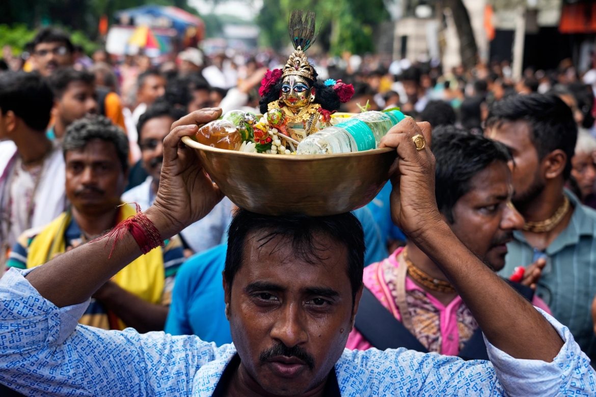 Một tín đồ Hindu giáo đội tượng thần Krishna trên đầu khi tham gia lễ hội Rath Yatra, tại thành phố Kolkata, thủ phủ bang Tây Bengal, miền Đông Ấn Độ.