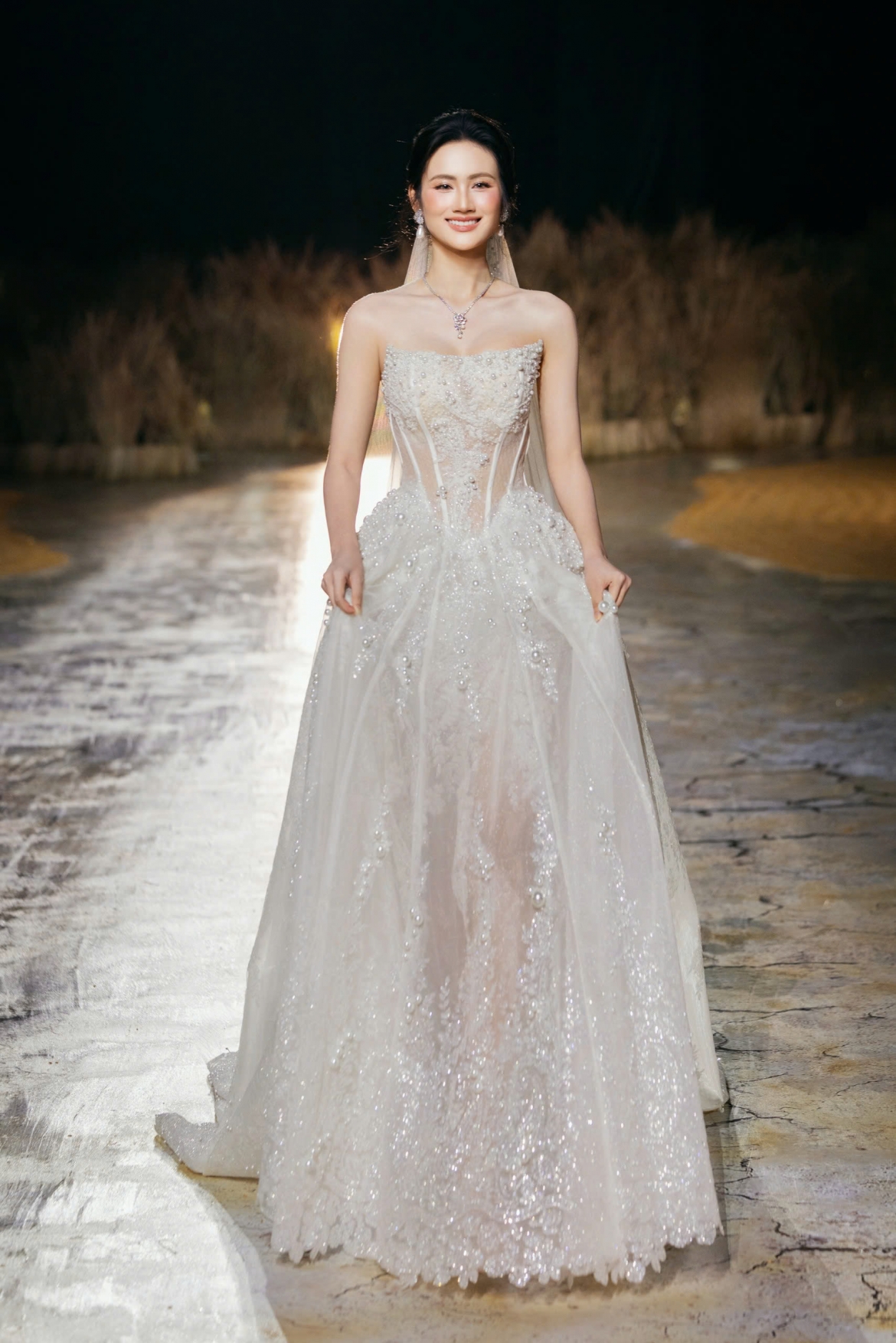 Hoa hậu Huỳnh Trần Ý Nhi xuất hiện ở vị trí vedette với những bước catwalk trên sân khấu phủ lúa.