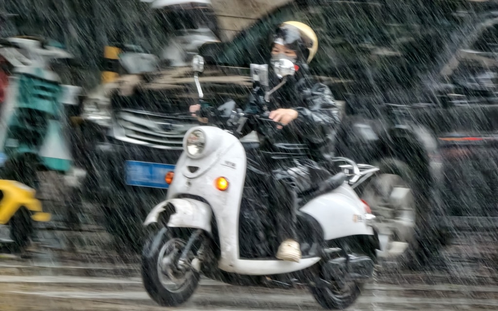 Người dân đi giữa gió và mưa tại Nam Ninh, Quảng Tây ngày 5/7. Ảnh: Tân Hoa xã.