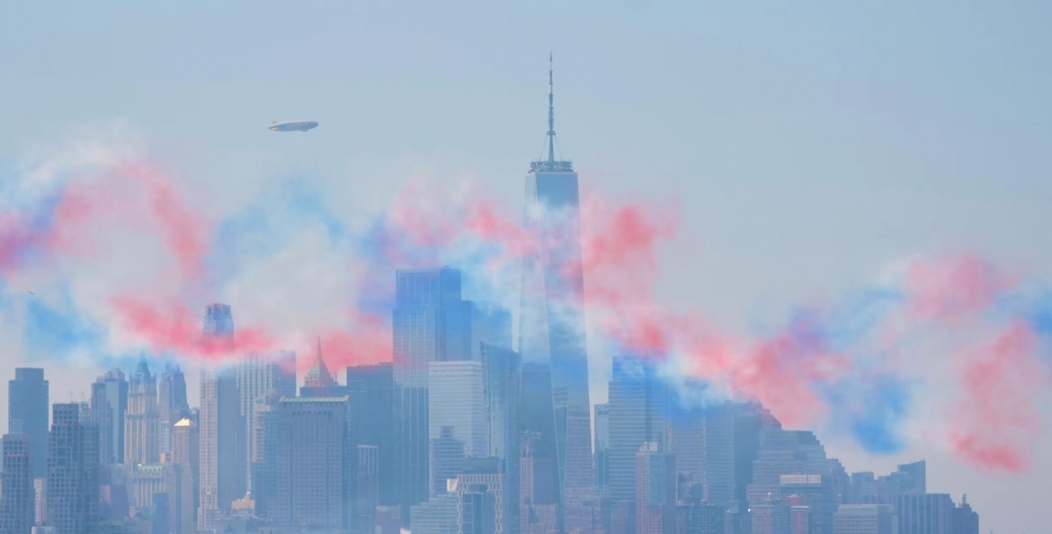 Một màn sương đỏ, trắng và xanh bao phủ đường chân trời Manhattan sau khi các máy bay quân sự thực hiện màn bay biểu diễn trên sông Hudson, nhìn từ Weehawken, New Jersey.