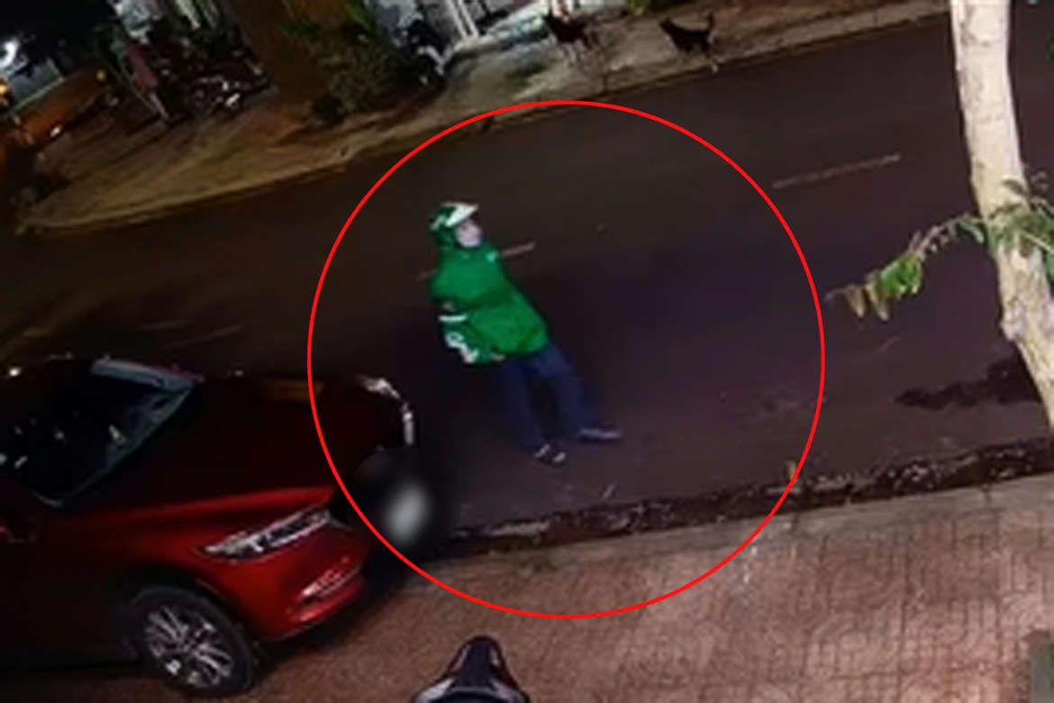 Nghi phạm mặc áo có chữ "Grab" áp sát nạn nhân và bắn 5 phát súng. (Ảnh: cắt từ clip nhà dân)