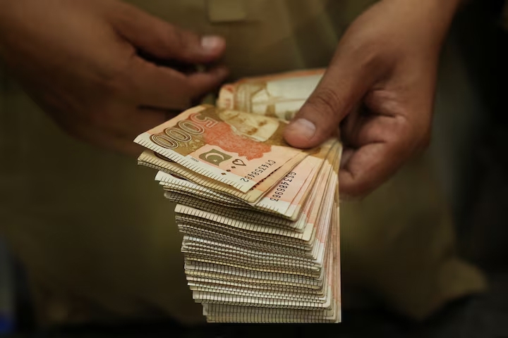Một nhân viên giao dịch đếm các tờ tiền rupee Pakistan tại một quầy đổi ngoại tệ ở thành phố Peshawar, Pakistan, ngày 29/7/2025. Ảnh: Reuters