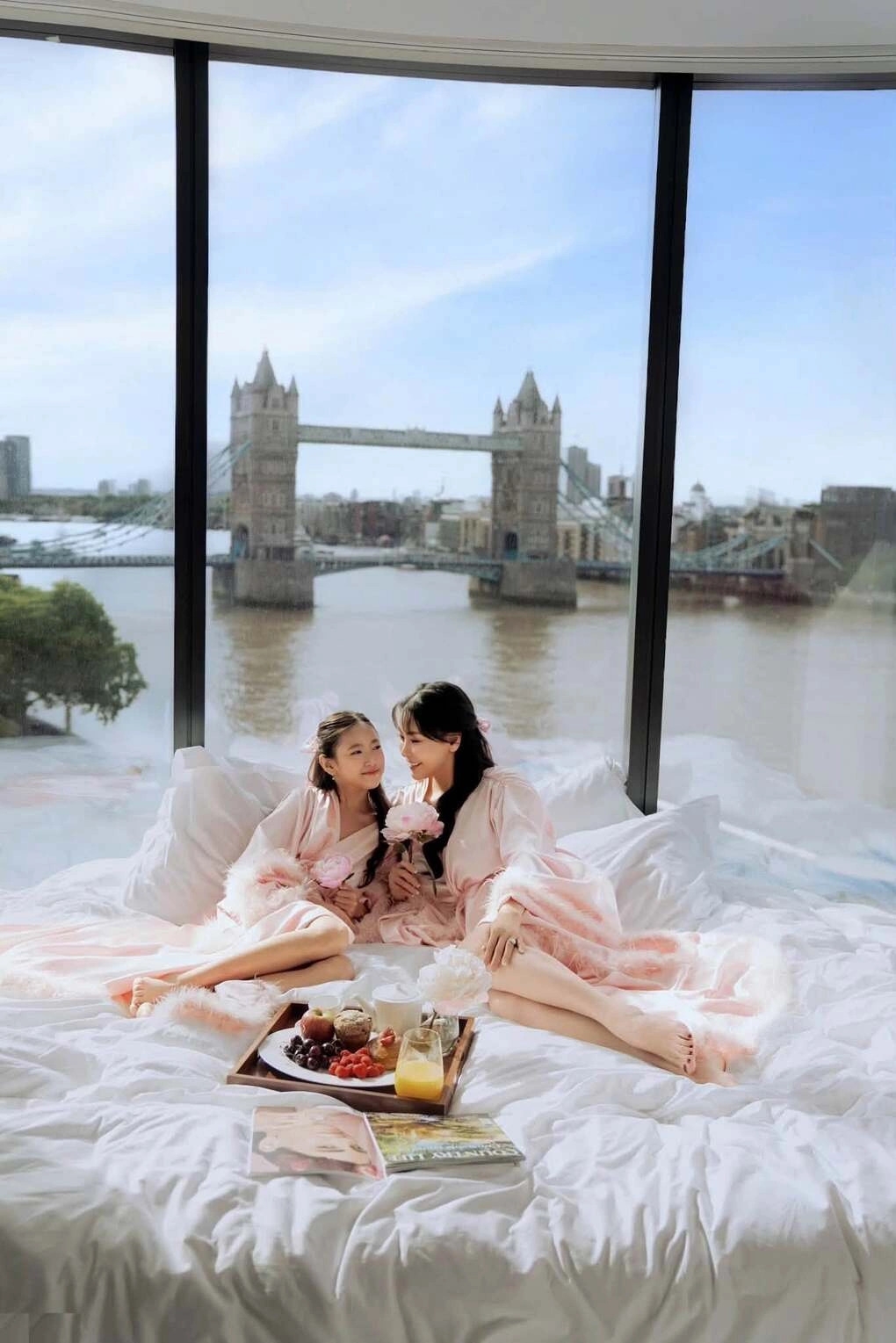 Hoa hậu Hà Kiều Anh cùng con gái Viann trải nghiệm bữa sáng tại giường ở khách sạn đắt đỏ, có "view triệu đô" với khung cửa kính lớn nhìn ra cây cầu Tower Bridge và sông Thames, thủ đô London (Anh). Ảnh: FBNV