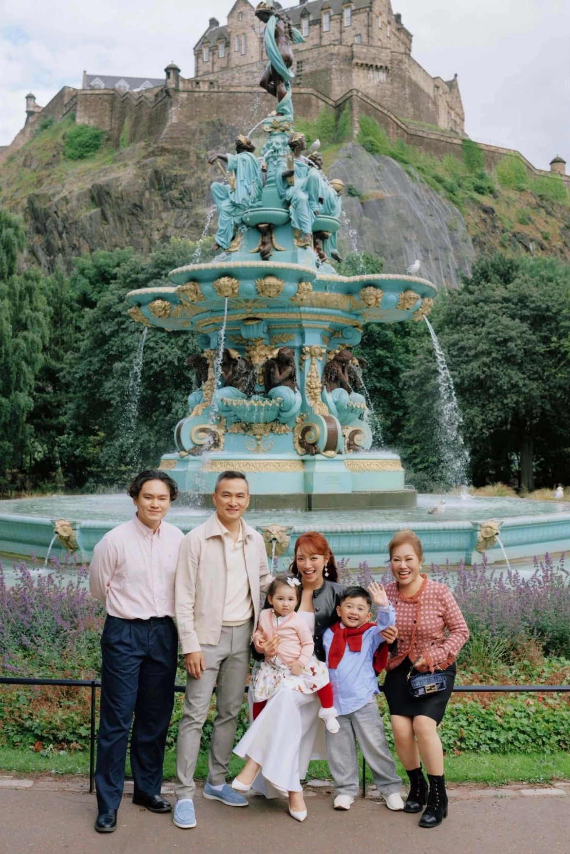 Chi Bảo cùng cả gia đình check-in ở đài phun nước Ross Fountain - công trình kiến trúc nổi tiếng ở Edinburgh. Con trai lớn của Chi Bảo (bìa trái) vui vẻ khi đi chơi cùng mẹ kế và các em. Ảnh: FBNV