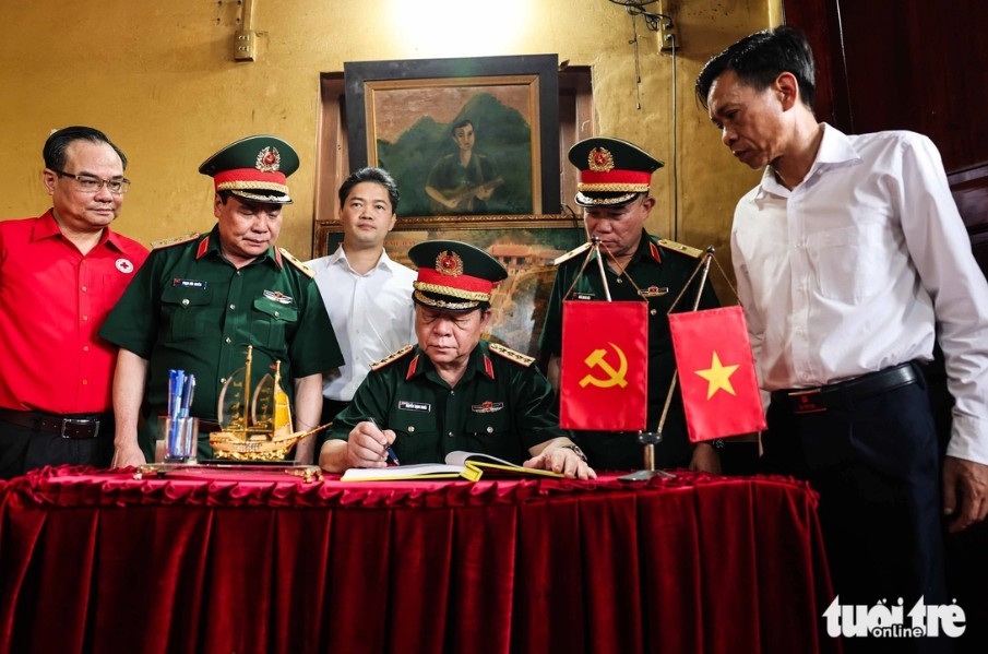Đại tướng Nguyễn Trọng Nghĩa ghi sổ lưu bút tại Đền thờ liệt sĩ điểm cao 468 - Ảnh: NGUYỄN KHÁNH