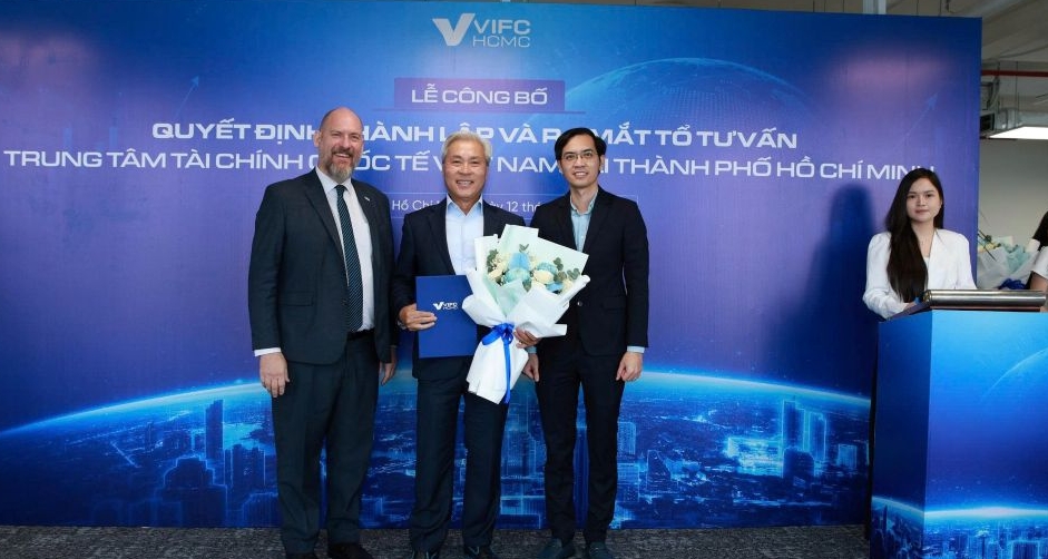 Phó Giáo sư -Tiến sĩ Nguyễn Hữu Huân -Phó Chủ tịch Cơ quan điều hành Trung tâm Tài chính quốc tế tại Việt Nam ở TP.HCM tặng hoa chúc mừng các thành viên Tổ Tư vấn. (Ảnh do VIFC-HCMC cung cấp)