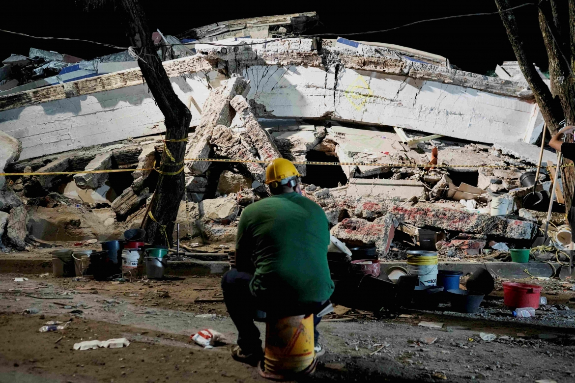 Một người đàn ông ngồi gần đống đổ nát sau trận động đất ở Cali, Colombia (Ảnh: Reuters)
