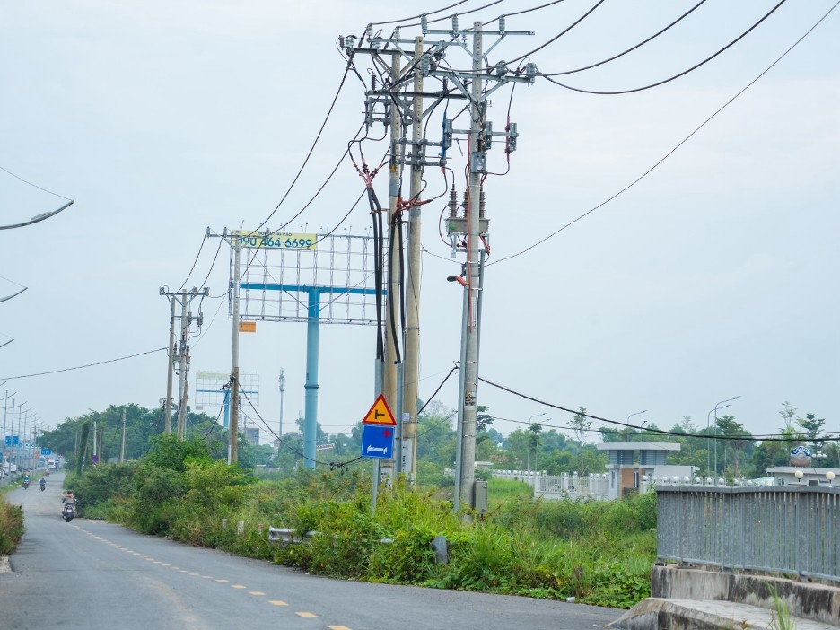 Dọc khu vực nút giao Chợ Đệm, nhiều trụ điện trung thế, đường dây cáp viễn thông, đường ống cấp nước… vẫn nằm trong phạm vi cần xử lý, nhà thầu không thể thi công vì không bảo đảm điều kiện an toàn.