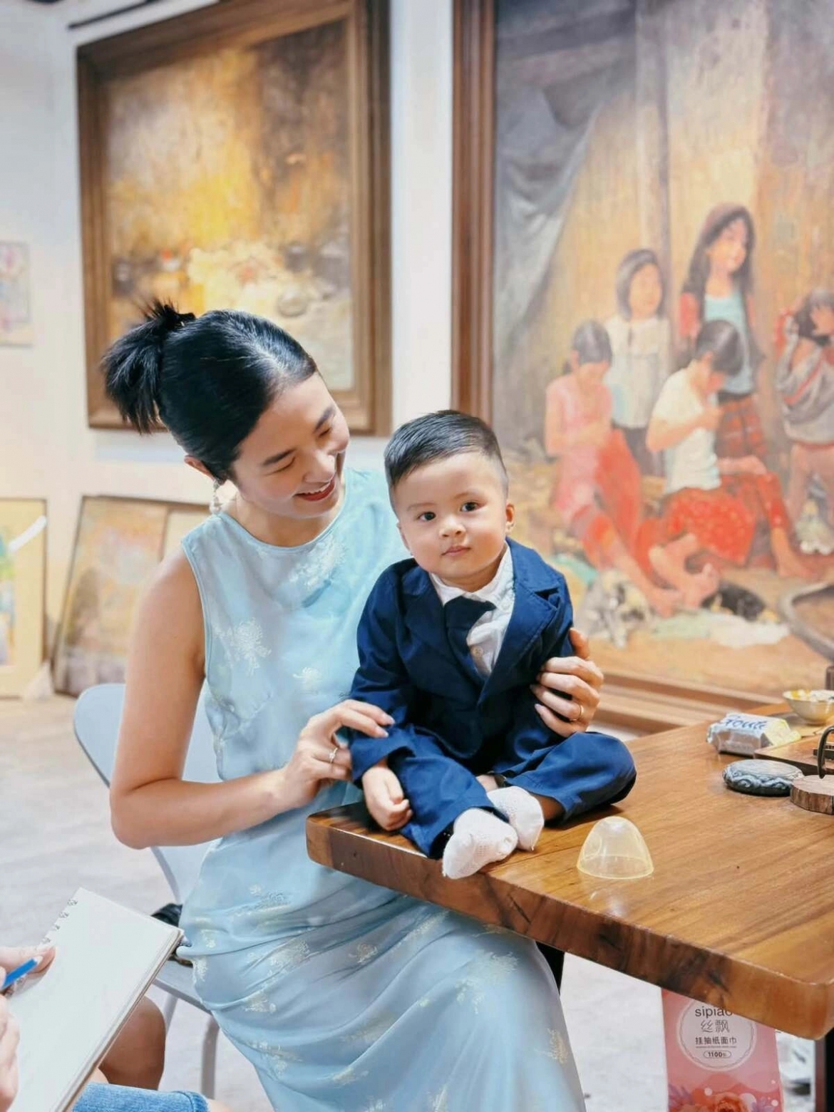 Quý tử nhà Hoa hậu Ngọc Hân được mẹ cho diện bộ suit xanh navy, sơ mi trắng và cà vạt nhỏ, trông bảnh bao, chững chạc. Cậu bé gây chú ý với vẻ ngoài đáng yêu khi ngồi bên mẹ.