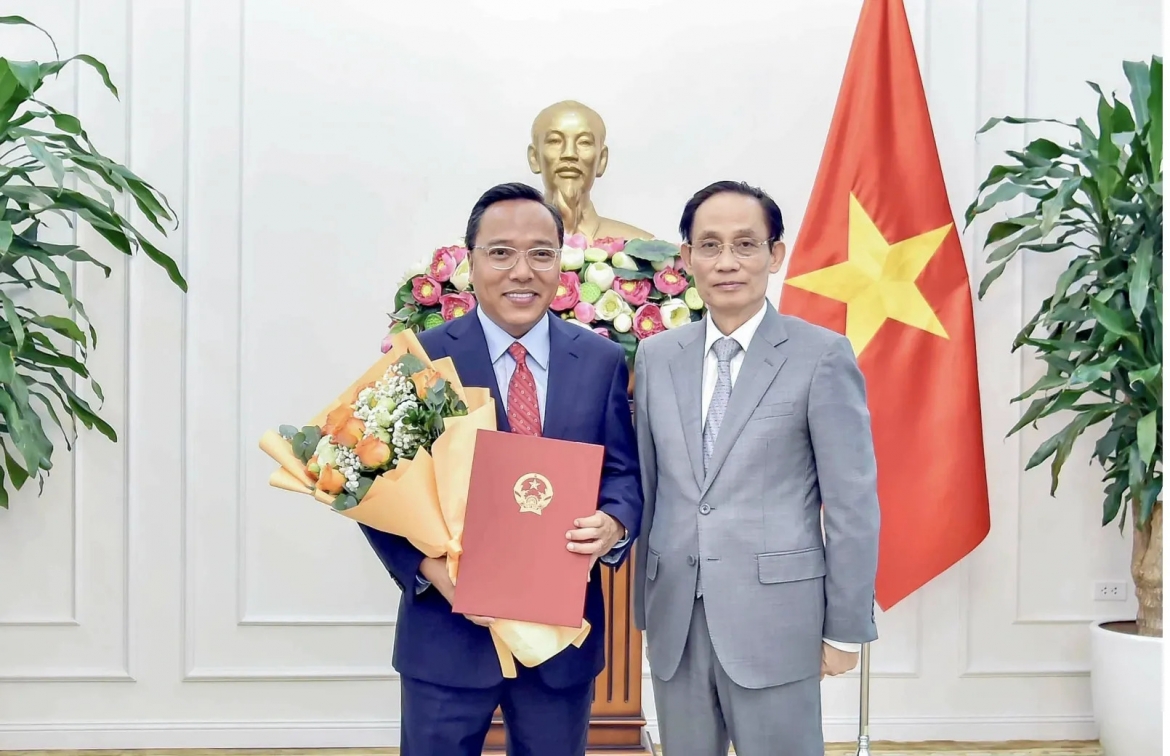 Bộ trưởng Bộ Ngoại giao Lê Hoài Trung trao quyết định của Thủ tướng Chính phủ và tặng hoa chúc mừng ông Nguyễn Hoàng Long được điều động, bổ nhiệm giữ chức Thứ trưởng Bộ Ngoại giao. (Ảnh: VGP)