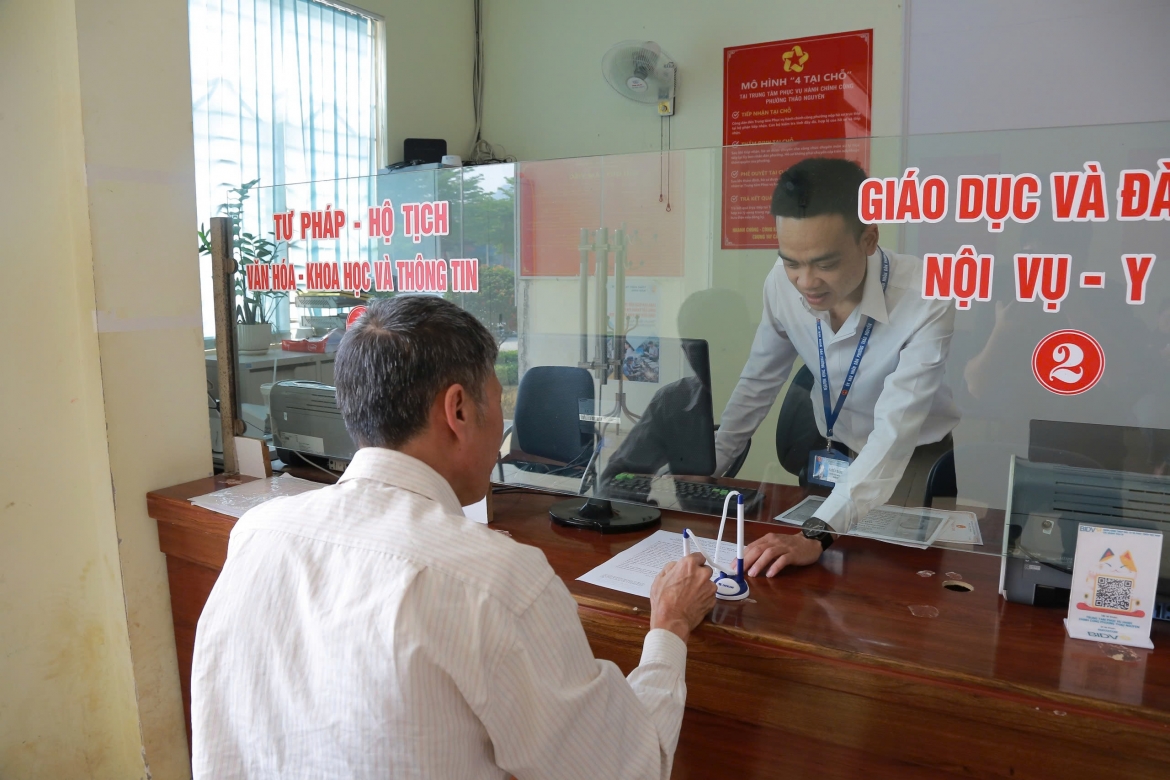 Công chức Trung tâm Phục vụ hành chính công phường Thảo Nguyên hướng dẫn người dân làm hồ sơ. Ảnh: Huy Thành